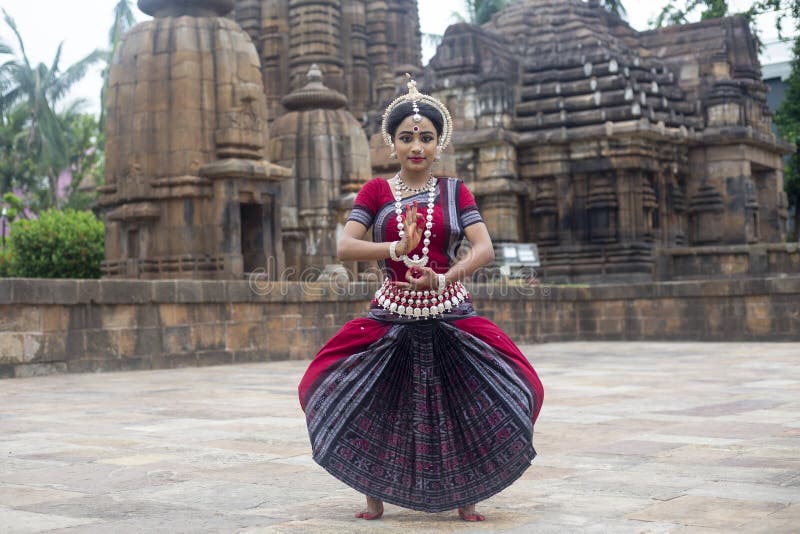 O dançarino clássico de Odissi veste a pose relevante do traje tradicional contra o contexto do templo de Mukteshvara, Bhubaneswa foto de stock royalty free O dançarino clássico de Odissi veste a pose relevante do traje tradicional contra o contexto do templo de Mukteshvara, Bhubaneswa foto de stock royalty free