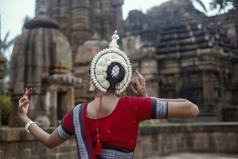 O dançarino clássico indiano do odissi veste o traje tradicional e o levantamento na frente do templo de Mukteshvara, Bhubaneswar foto de stock O dançarino clássico indiano do odissi veste o traje tradicional e o levantamento na frente do templo de Mukteshvara, Bhubaneswar foto de stock