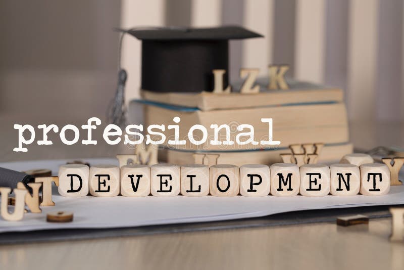 Word PROFESSIONAL DEVELOPMENT composed of wooden dices. Black graduate hat and books in the background. Closeup. Word PROFESSIONAL DEVELOPMENT composed of wooden dices. Black graduate hat and books in the background. Closeup