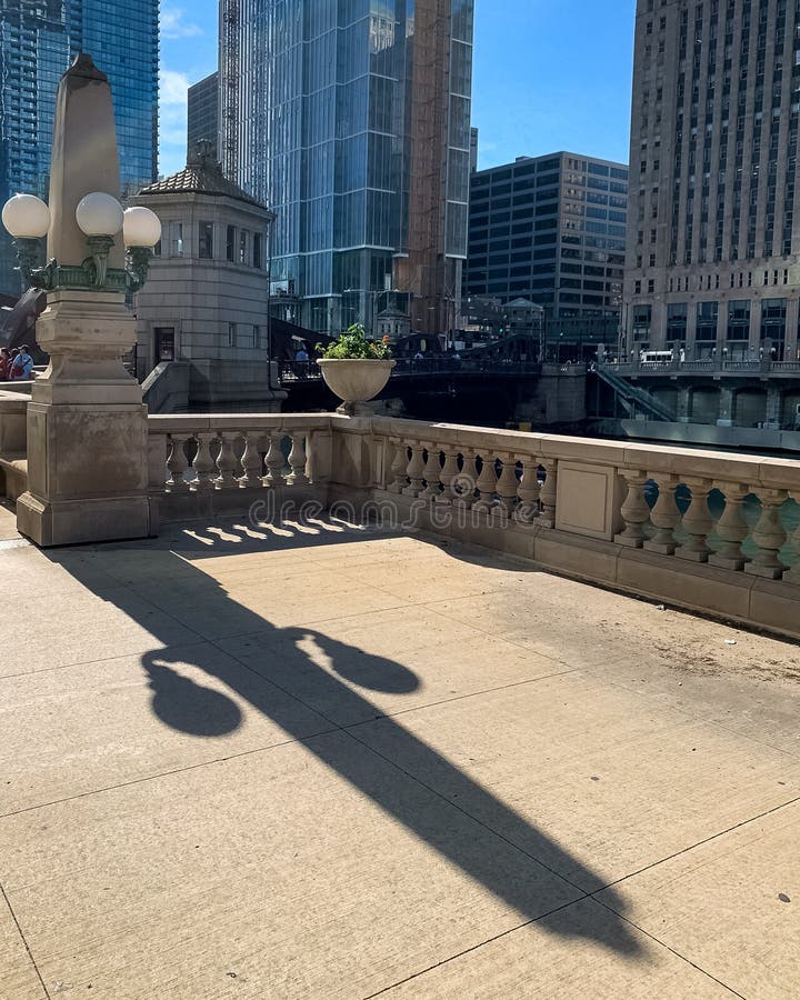 O dispositivo elétrico claro no laço de Chicago cria uma sombra longa do verão no passeio da movimentação de Wakcer imagens de stock royalty free O dispositivo elétrico claro no laço de Chicago cria uma sombra longa do verão no passeio da movimentação de Wakcer imagens de stock royalty free