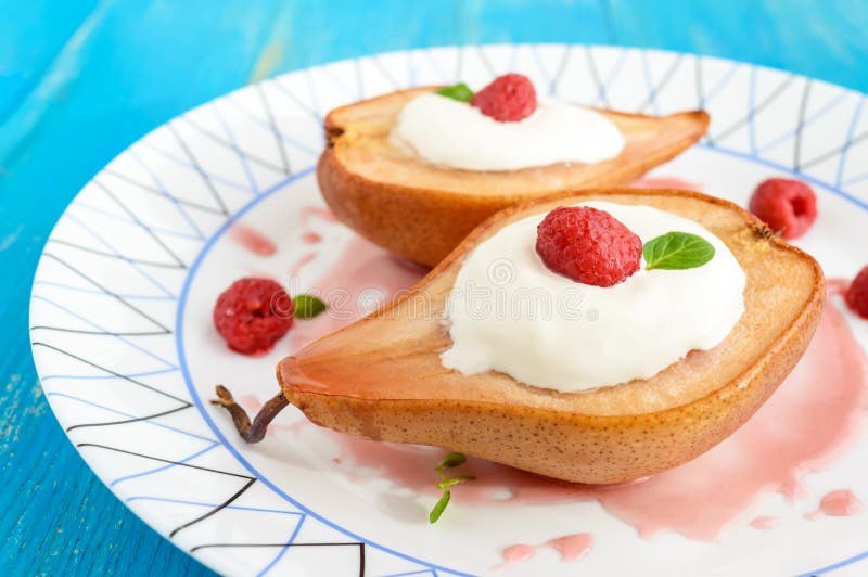 O doce cozeu a pera com creme, xarope da framboesa, as framboesas frescas no açúcar e as folhas de hortelã Sobremesa em um fundo fotografia de stock royalty free O doce cozeu a pera com creme, xarope da framboesa, as framboesas frescas no açúcar e as folhas de hortelã Sobremesa em um fundo fotografia de stock royalty free
