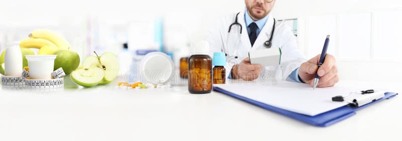 O doutor do nutricionista escreve a prescrição médica para um correc foto de stock royalty free O doutor do nutricionista escreve a prescrição médica para um correc foto de stock royalty free