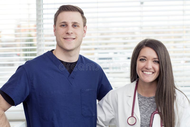 O doutor e o homem fêmeas nutrem o sorriso no escritório foto de stock O doutor e o homem fêmeas nutrem o sorriso no escritório foto de stock