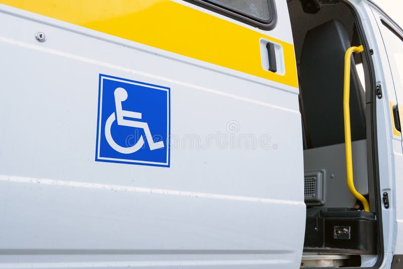 O estar aberto de um veículo especializado para povos com inabilidades Ônibus branco com um sinal azul para os enfermos Barra ama fotos de stock O estar aberto de um veículo especializado para povos com inabilidades Ônibus branco com um sinal azul para os enfermos Barra ama fotos de stock