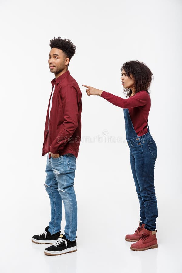 O estúdio disparou da mulher irritada nova que aponta o dedo a seu noivo com expressão séria imagem de stock royalty free O estúdio disparou da mulher irritada nova que aponta o dedo a seu noivo com expressão séria imagem de stock royalty free