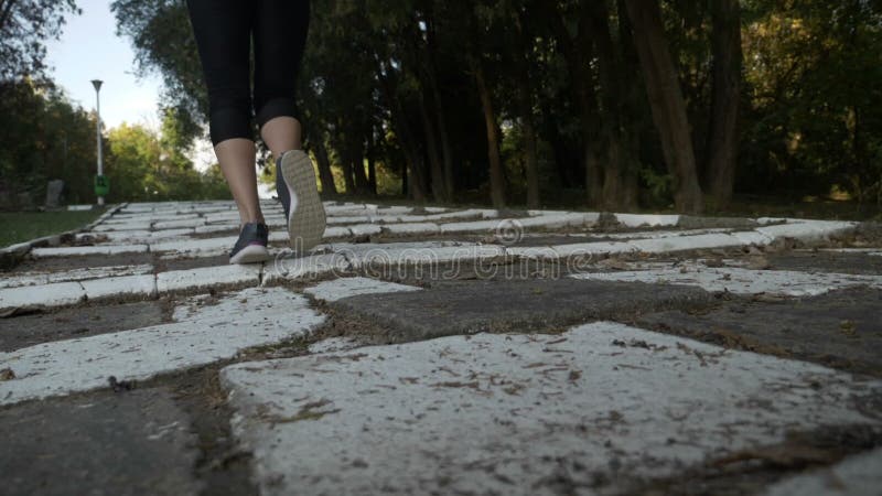 O fată atrăgătoare și slăbănoagă, cu mușchi tonați pe picior, alergând pe o alee albă, parcând scările în mișcare lentă stock video footage