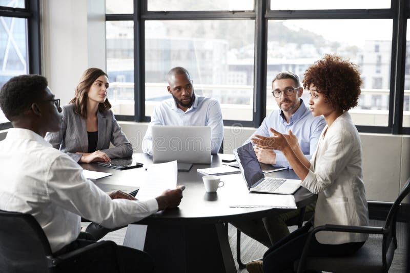 O femeie de afaceri generoasă a Mileniului care se adresează colegilor de la o întâlnire de afaceri a unei corporații stock photos