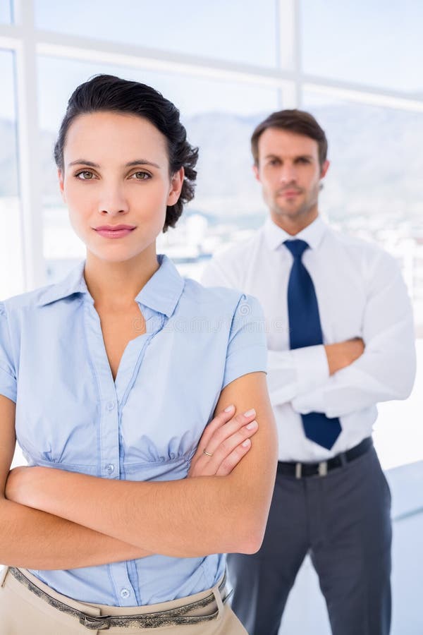 O femeie de afaceri serioasă cu un coleg de sex masculin pe fundal stock photos