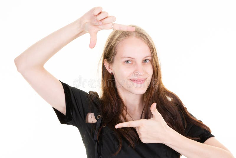 O femeie frumoasă zâmbind și făcând o fotografie goală cu degetele în fundal alb în studio stock photos