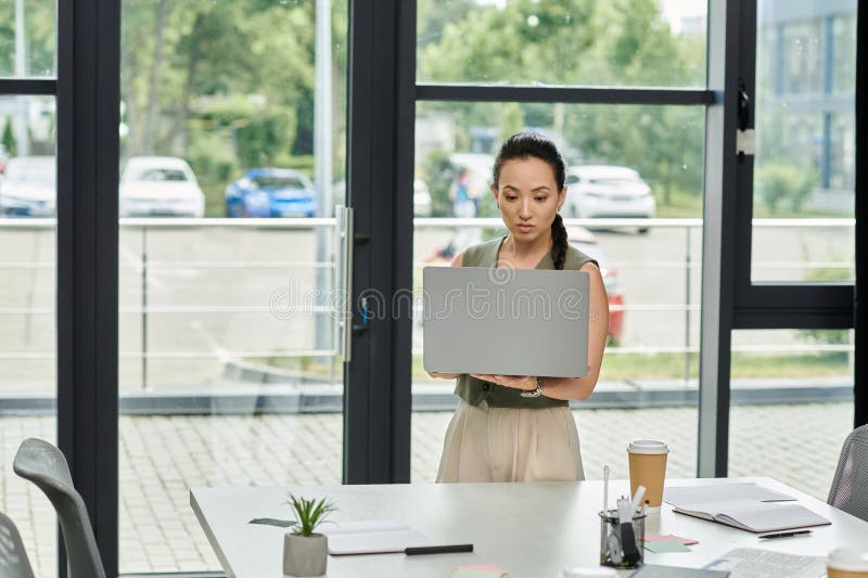 O femeie profesionistă concentrată se află în stock photo