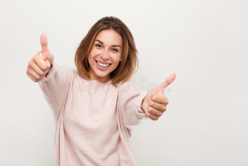 O femeie veselă gestând degetele în sus stock images