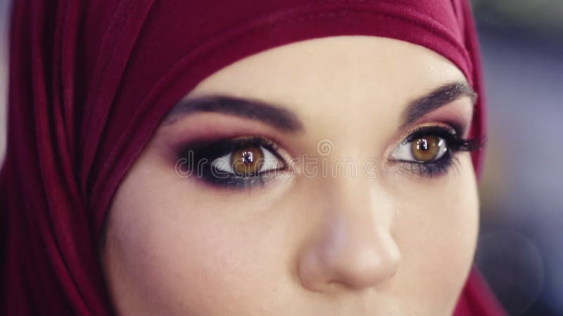 O fim do movimento lento acima da metragem de um hijab vestindo da menina que abre seus olhos com o smokey colorido perfeito comp