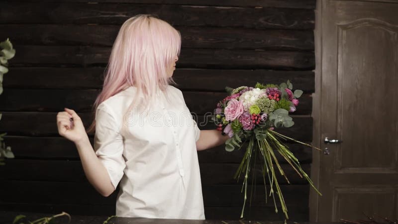 O florista profissional na camisa branca decora um ramalhete elegante que complementa com as flores para o perfeito vídeos de arquivo O florista profissional na camisa branca decora um ramalhete elegante que complementa com as flores para o perfeito vídeos de arquivo