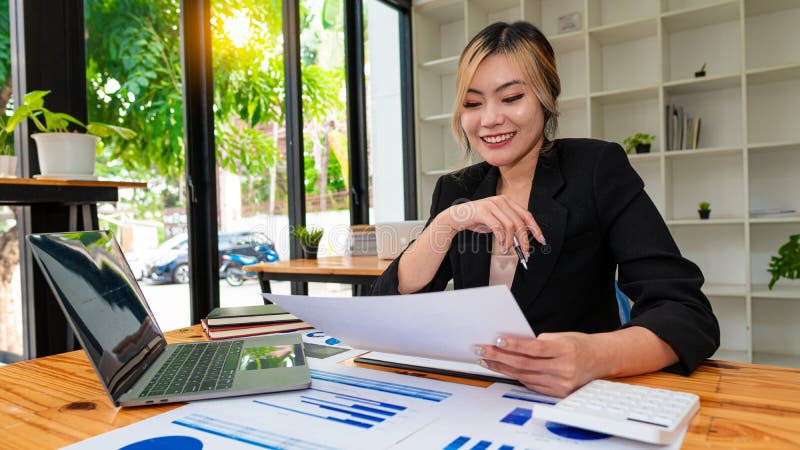 O frumoasă femeie designer de modă asiatică care e fericită că zâmbește cu mândrie la ea în studioul ei cu manechine și colorat pa royalty free stock photography