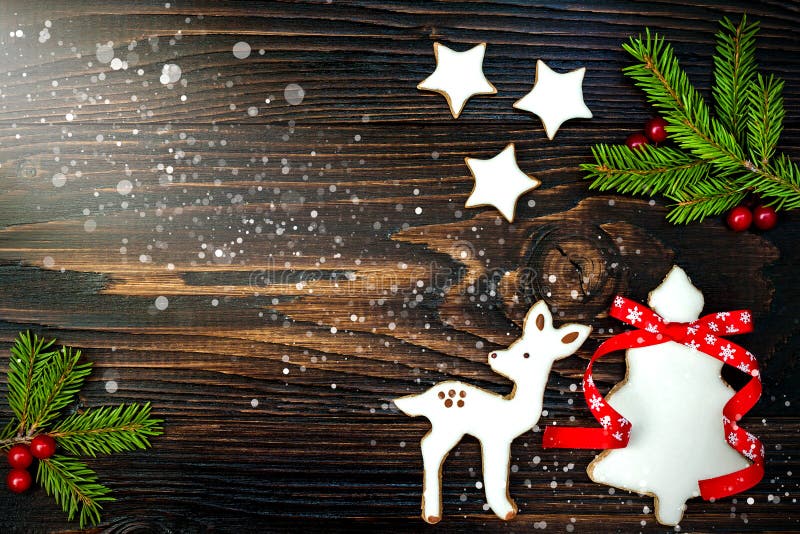 O fundo do feriado do Natal com cookies e abeto do pão-de-espécie ramifica na placa de madeira velha Copie o espaço fotografia de stock O fundo do feriado do Natal com cookies e abeto do pão-de-espécie ramifica na placa de madeira velha Copie o espaço fotografia de stock