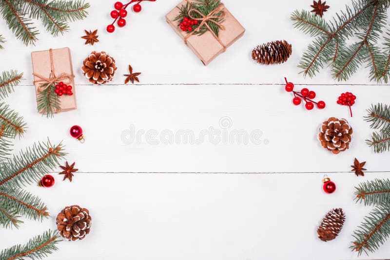 O fundo do Natal com presente do Natal, abeto ramifica, cones do pinho, flocos de neve, decorações vermelhas Xmas e ano novo feli