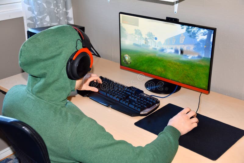 O Gamer ou a fl?mula nos fones de ouvido com microfone sentam-se em casa na sala escura e nos jogos com os amigos em redes foto de stock royalty free O Gamer ou a fl?mula nos fones de ouvido com microfone sentam-se em casa na sala escura e nos jogos com os amigos em redes foto de stock royalty free