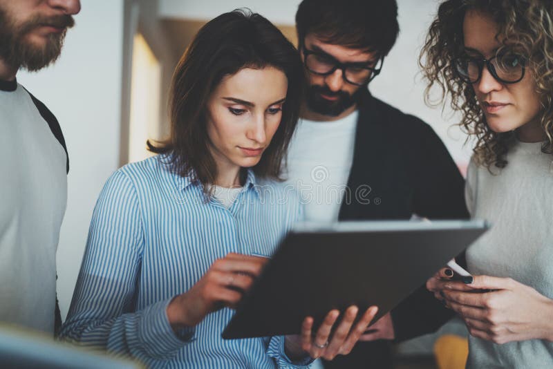 O grupo de empresários novos está procurando uma solução do negócio durante o tempo de funcionamento no escritório ensolarado fotografia de stock O grupo de empresários novos está procurando uma solução do negócio durante o tempo de funcionamento no escritório ensolarado fotografia de stock