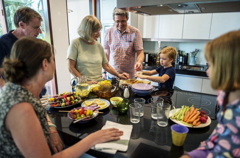 O grupo de povos caucasianos que preparam o assado party no kitche imagens de stock O grupo de povos caucasianos que preparam o assado party no kitche imagens de stock