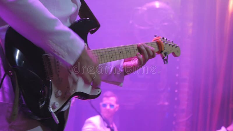 O guitarrista irreconhecível joga a guitarra no concerto