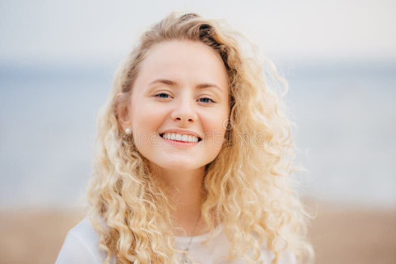 O Headshot da mulher bonita com sorriso amigável, tem a pele saudável, sendo no bom humor após o resto inesquecível no país w do imagem de stock royalty free O Headshot da mulher bonita com sorriso amigável, tem a pele saudável, sendo no bom humor após o resto inesquecível no país w do imagem de stock royalty free