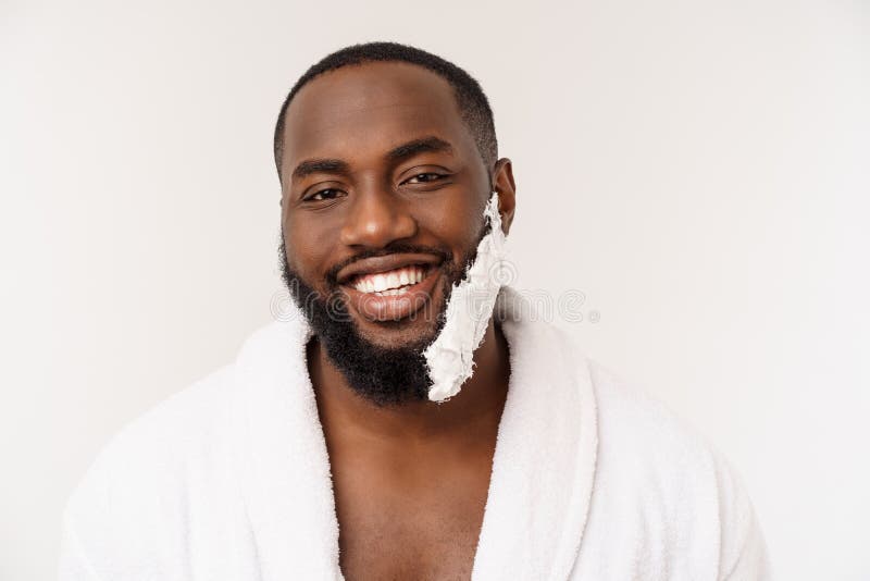 O homem afro-americano mancha o creme de rapagem na cara pela escova de rapagem Higiene masculina Isolado no fundo branco est?dio fotografia de stock O homem afro-americano mancha o creme de rapagem na cara pela escova de rapagem Higiene masculina Isolado no fundo branco est?dio fotografia de stock
