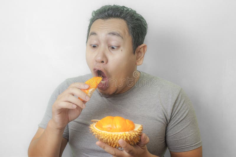 O homem asi?tico engra?ado aprecia o fruto do Durian fotografia de stock O homem asi?tico engra?ado aprecia o fruto do Durian fotografia de stock