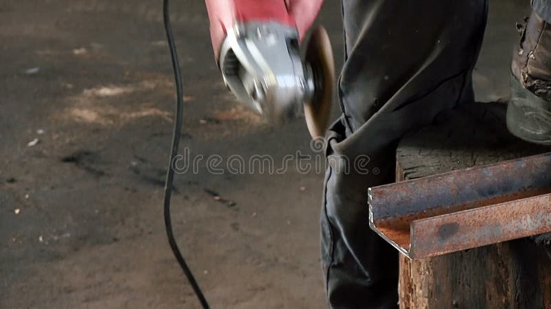 O homem corta um feixe oxidado do metal, usando uma turbina circular Som terminado slowmotion do trabalho do moedor de ângulo