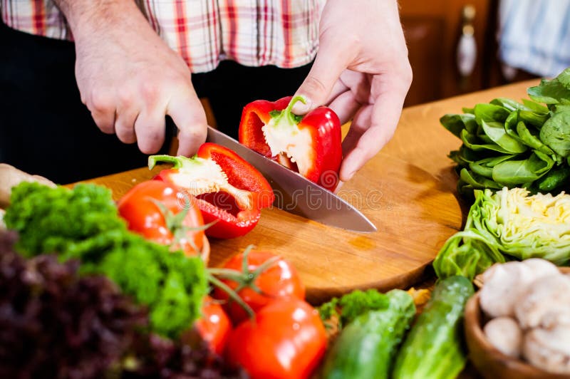 O homem corta vegetais frescos da mola foto de stock O homem corta vegetais frescos da mola foto de stock