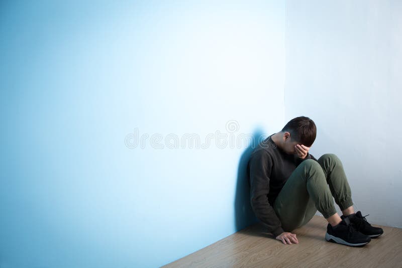 O homem da depressão senta-se no assoalho imagem de stock royalty free O homem da depressão senta-se no assoalho imagem de stock royalty free