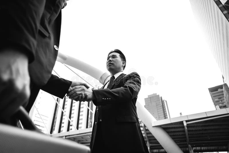 O homem de negócios considerável é de cumprimento e de verificação a mão a seu cliente fotos de stock royalty free O homem de negócios considerável é de cumprimento e de verificação a mão a seu cliente fotos de stock royalty free