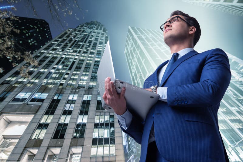 O homem de negócios contra construções no conceito do negócio fotografia de stock royalty free O homem de negócios contra construções no conceito do negócio fotografia de stock royalty free
