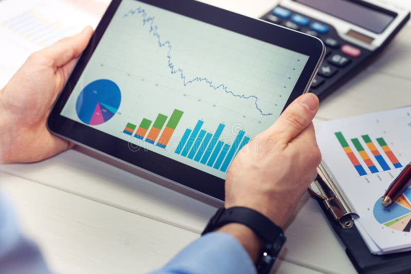 Businessman holding digital tablet with graphs and charts report on screen. Businessman holding digital tablet with graphs and charts report on screen