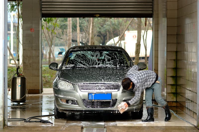 O homem de Yaan China-Um está limpando o carro imagens de stock O homem de Yaan China-Um está limpando o carro imagens de stock