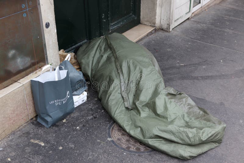 Homeless man curled up under a plastic tarpaulin, asleep on the street, May 1, 2013 in Paris, France. Today, France has 130,000 homeless, and every day one of them dies. Homeless man curled up under a plastic tarpaulin, asleep on the street, May 1, 2013 in Paris, France. Today, France has 130,000 homeless, and every day one of them dies