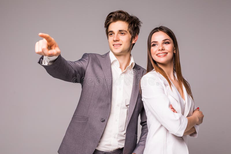 O homem e a mulher de negócio em um fundo cinzento Homem aguçado afastado no cinza foto de stock royalty free O homem e a mulher de negócio em um fundo cinzento Homem aguçado afastado no cinza foto de stock royalty free
