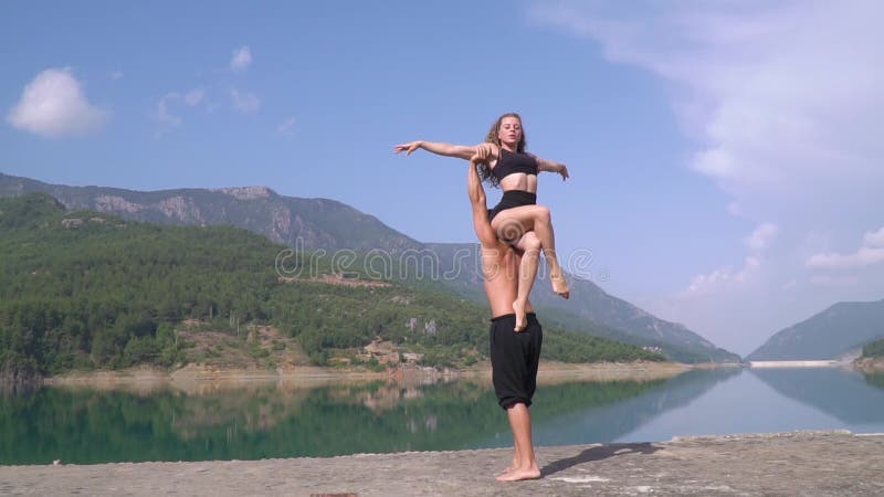 O homem e a mulher na natureza treinam antes de seu desempenho