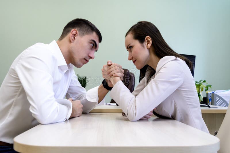 O homem e a mulher no escritório vestem atracar-se disponível na mesa no escritório imagem de stock royalty free O homem e a mulher no escritório vestem atracar-se disponível na mesa no escritório imagem de stock royalty free