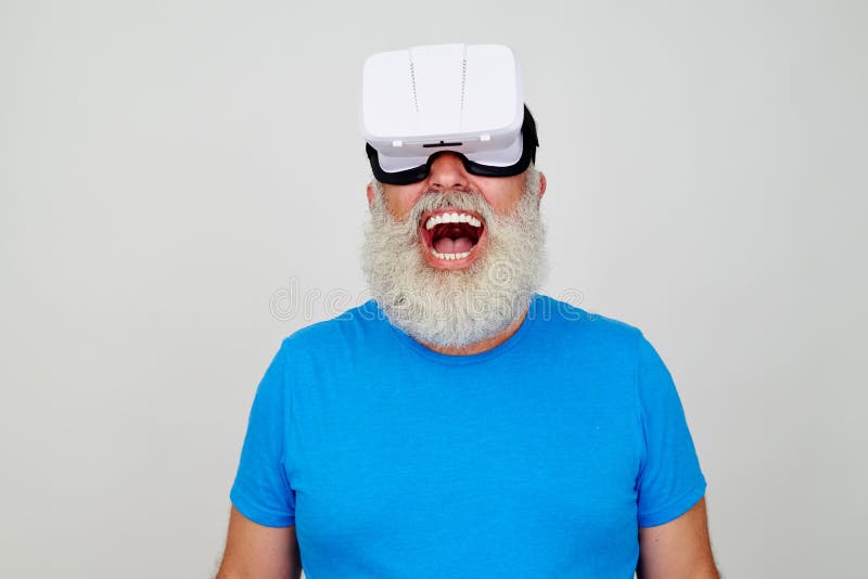 O homem envelhecido de sorriso deleitou-se pelo efeito da cabeça da realidade virtual foto de stock O homem envelhecido de sorriso deleitou-se pelo efeito da cabeça da realidade virtual foto de stock