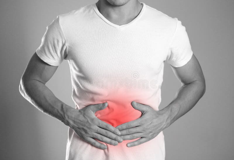 The man is holding his stomach. Abdominal pain. The hearth is highlighted in red. Close up. Isolated background. The man is holding his stomach. Abdominal pain. The hearth is highlighted in red. Close up. Isolated background.