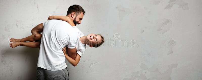 O homem farpado guarda nas mãos um rapaz pequeno no foto de stock royalty free O homem farpado guarda nas mãos um rapaz pequeno no foto de stock royalty free