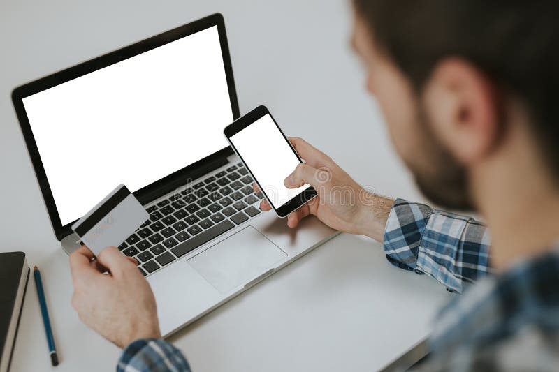 O homem faz o pagamento pelo cartão de crédito no telefone imagem de stock O homem faz o pagamento pelo cartão de crédito no telefone imagem de stock