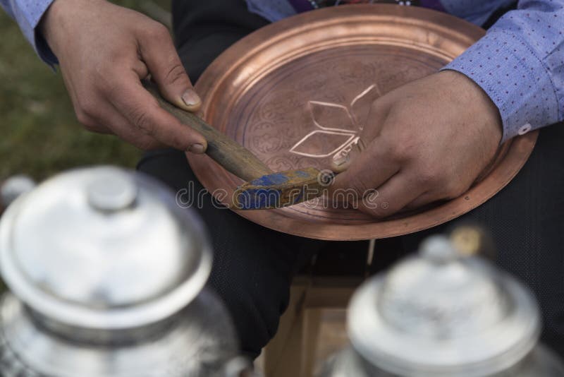 O homem fazendo padrão na placa de cobre imagens de stock O homem fazendo padrão na placa de cobre imagens de stock