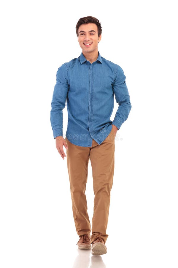 O homem novo de sorriso está andando e olha para tomar partido imagens de stock O homem novo de sorriso está andando e olha para tomar partido imagens de stock