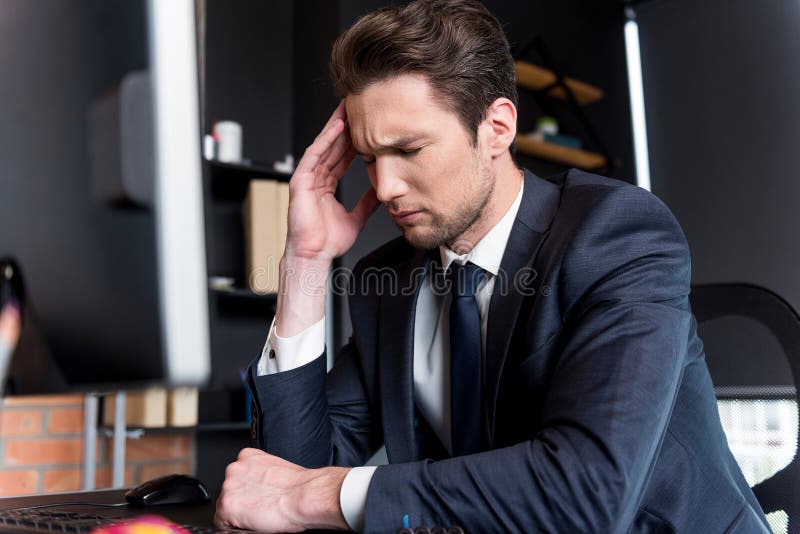 O homem novo deprimido está tendo a dor de cabeça fotografia de stock royalty free O homem novo deprimido está tendo a dor de cabeça fotografia de stock royalty free