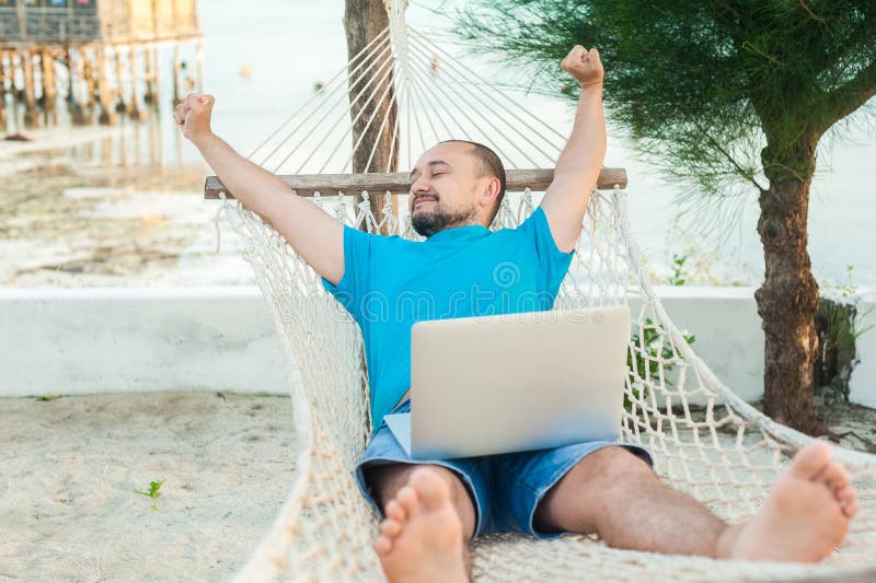 O homem novo encontra-se em uma rede e está-se feliz com um t bem sucedido imagem de stock royalty free O homem novo encontra-se em uma rede e está-se feliz com um t bem sucedido imagem de stock royalty free