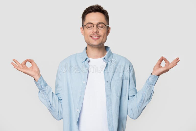 O homem novo faz o gesto do mudra medita a posição sobre o fundo cinzento fotografia de stock royalty free O homem novo faz o gesto do mudra medita a posição sobre o fundo cinzento fotografia de stock royalty free