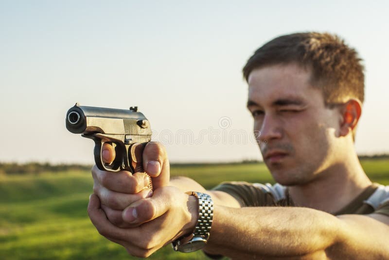 O homem novo tomou o alvo com pistola imagens de stock royalty free O homem novo tomou o alvo com pistola imagens de stock royalty free