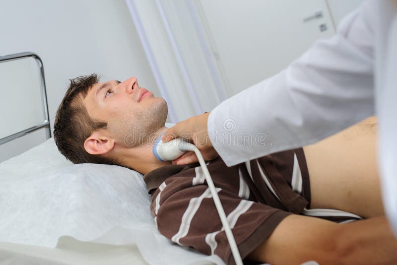 O homem pacient no exame da ecografia no pescoço imagem de stock O homem pacient no exame da ecografia no pescoço imagem de stock