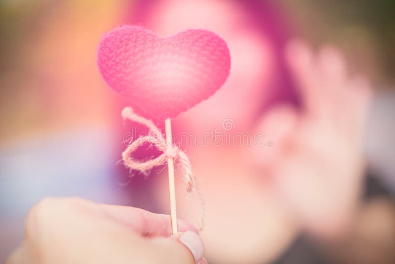 o homem para dar um coração cor-de-rosa às mulheres entrega a aprovação no fundo do borrão imagens de stock royalty free o homem para dar um coração cor-de-rosa às mulheres entrega a aprovação no fundo do borrão imagens de stock royalty free